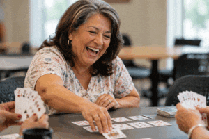 Senior woman back to playing cards with friends after learnign How much does cataract surgery cost at Wellish Abrams Vision Institute in Las Vegas and Henderson, Nevada.