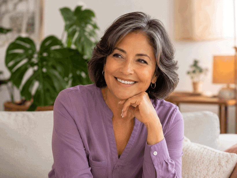 Smiling senior Hispanic woman at home, representing eye care for seeing spots in vision at Wellish Abrams Vision Institute
