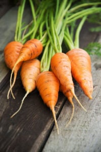 Fresh carrots on a table, a vitamin A-rich food that supports eye health and healthy vision.
