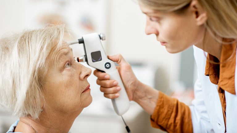 Clinic image of a woman having a pressure sheck with a hand held tonometer.