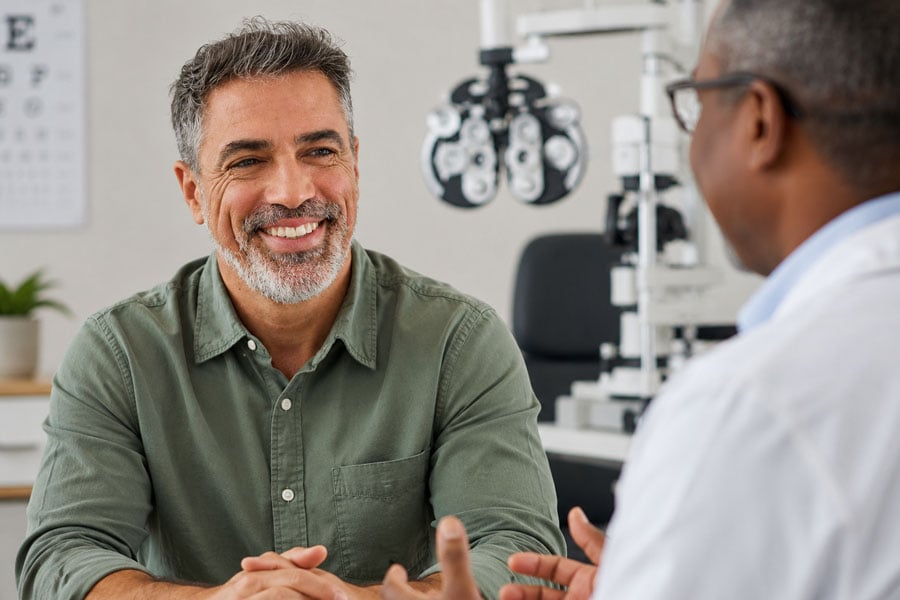 Patient discussing cataract surgery options with an eye doctor during a consultation in a bright exam room.
