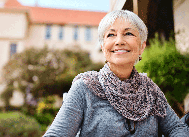 Senior woman smiling outdoors, representing healthy vision and the importance of eye exams for high eye pressure and glaucoma at Wellish Abrams Vision Institute.