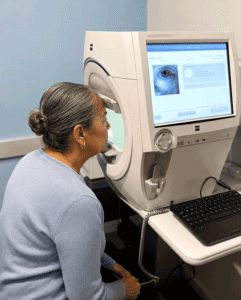 Senior Hispanic woman completing a visual field test during a cataract evaluation at Wellish Abrams Vision Institute.