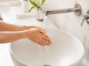 Hands washing at a clean sink before applying glaucoma eye drops, illustrating safe eye drop use for Wellish Abrams Vision Institute.