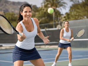 Woman happily playing tennis with a friend, representing active lifestyle goals for patients asking is LASIK safe at Wellish Abrams Vision Institute.