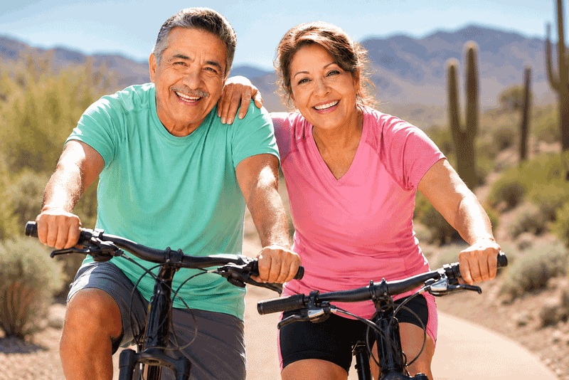Active senior couple riding bicycles in Nevada, illustrating lifestyle considerations when comparing the Light Adjustable Lens vs standard lens at Wellish Abrams Vision Institute
