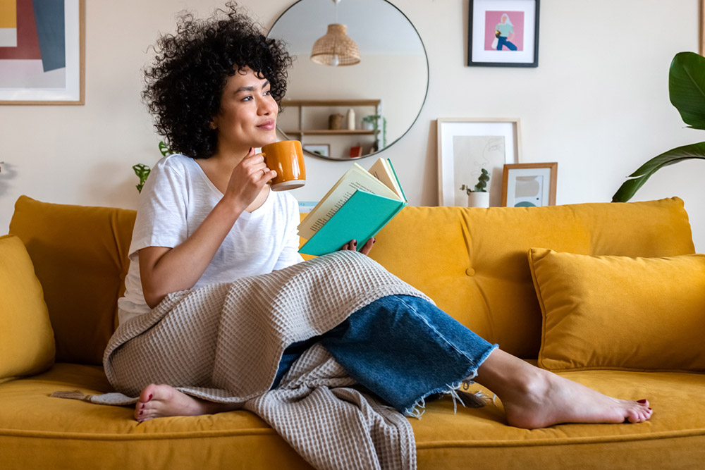 Woman reading comfortably at home after PRK eye surgery.